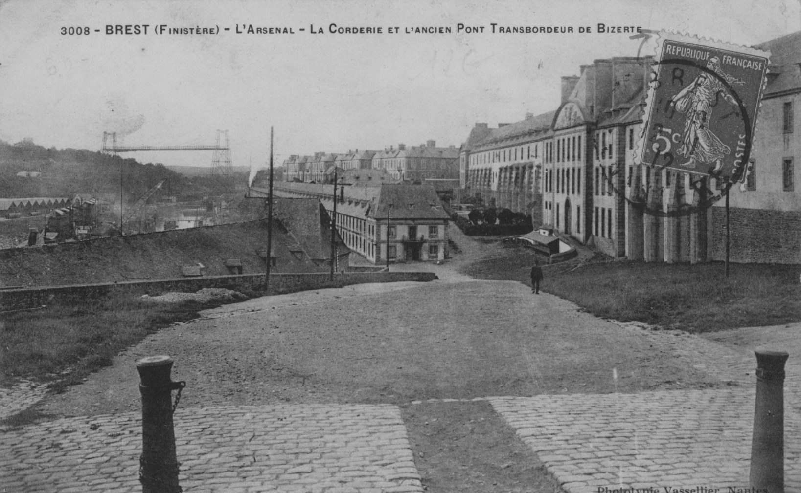 Carte postale ancienne en noir et blanc : une très longue façade de bâtiments de l'arsenal, au-dessus de la Penfeld