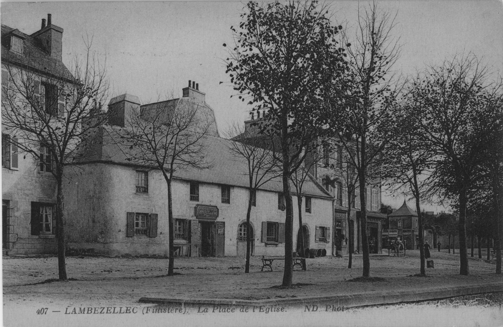 Carte postale ancienne en noir et blanc : la place de l'église de Lambézellec, plantée d'arbres, des maisons basses et des commerces